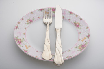 knife, fork and plate on a white background