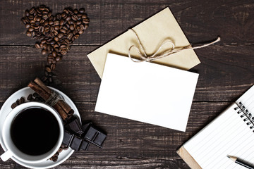 coffee cup and heart shaped beans with greeting card and notebook