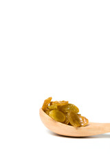 A driend raisin in a wooden spoon isolated over white background