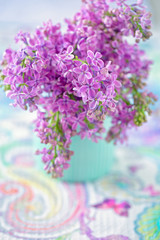 Bouquet of lilacs flowers in a vase on the table.