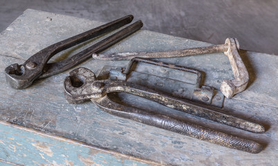 different types of pincers over old tools for housework, vintage look, over old wooden toolbox, timeworn paint