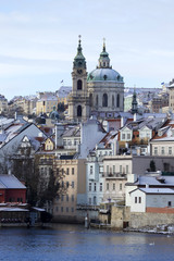 Obraz premium Snowy freeze Prague Lesser Town with St. Nicholas' above River Vltava, Czech republic 