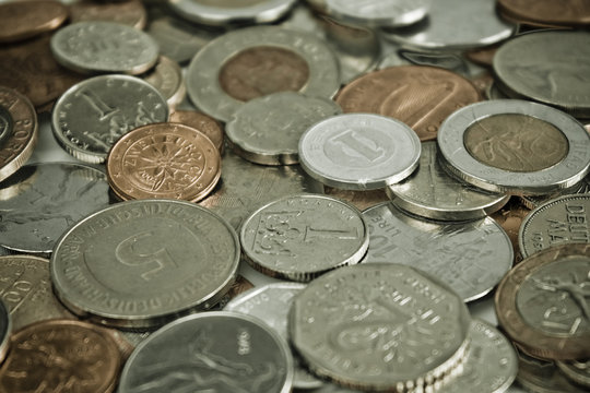 Coins of several currencies - background pattern. Close up picture taken in studio.