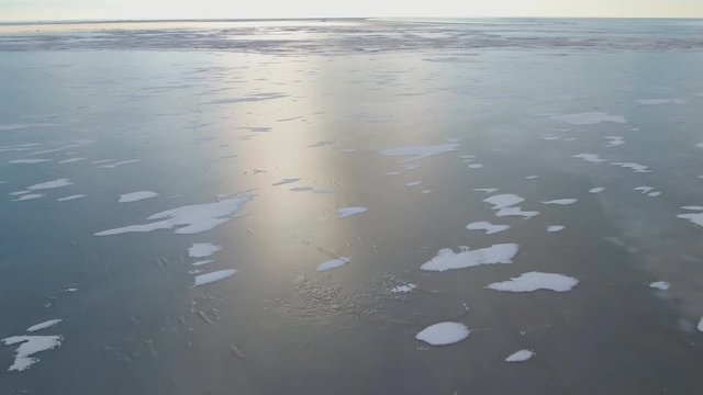 Flying over sea. Frozen sea covered with a thick layer of ice. Aerial view.