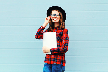 Fashion pretty young smiling woman holding laptop computer or ta