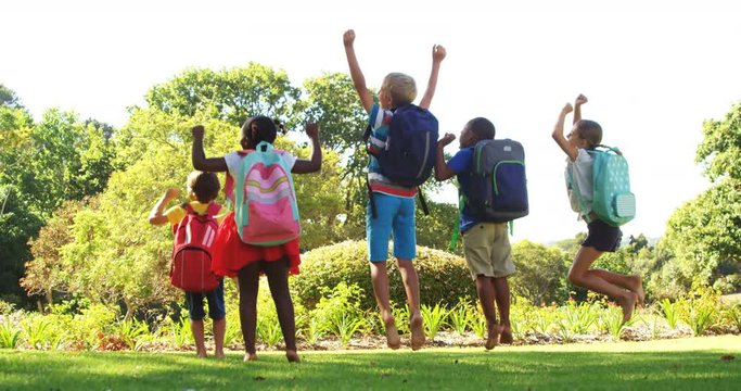 Group of kids jumping together in park on a sunny day 4k 