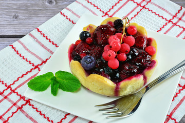 Fruit tarts with berries, vanilla custard and jelly on white plate