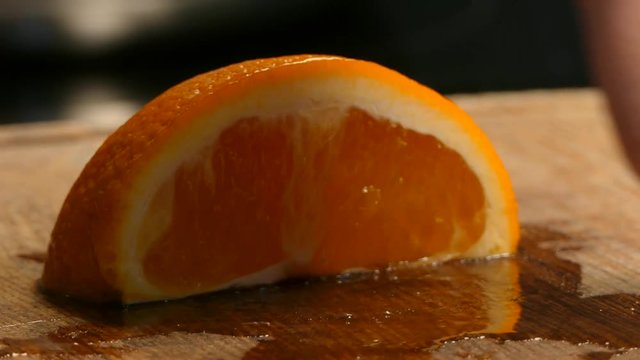 Close-up. Women's hands cut juicy orange wedges