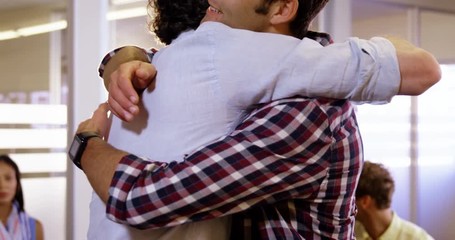 Two mens hugging each other while colleagues clapping in background at office 4k
