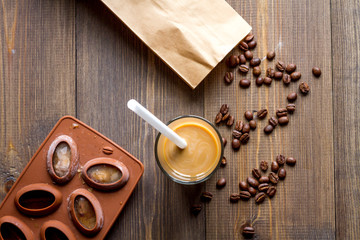 coffee with ice in glass on wooden background top view