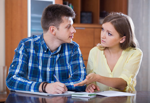 family couple at desk with financial documents indoors