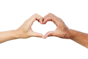 Hands of the female elderly and a young woman forming a heart shape together / Love and care...