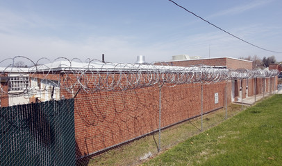 Old brick walled county jail topped with razor wire. Horizontal.