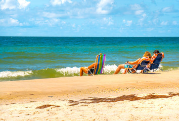 Tourists on beach vacation enjoy ocean water views St George Island Florida