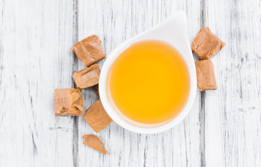 Caramel Sirup (selective focus) on vintage wooden background