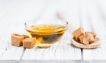 Caramel Syrup on wooden background (selective focus)