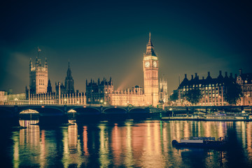 Iconic view Westminster with Big Ben, Houses of Parliament and Thames at Victoria Embankment lit up at night.