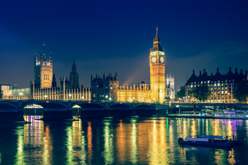 Iconic view Westminster with Big Ben, Houses of Parliament and Thames at Victoria Embankment lit up at night.