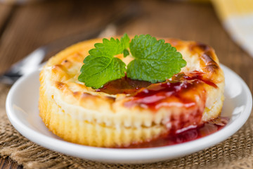 Cheesecake with berry Sacue (selective focus) on vintage wooden