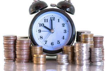 Double exposure rows of coins and alarm clock with city background, Finance and money saving concept