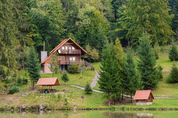 House near the lake in the forest, autumn day.