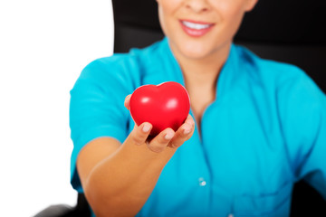 Young female doctor holding toy heart