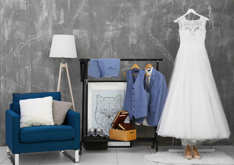 Bride dress and groom suit in dressing room indoors
