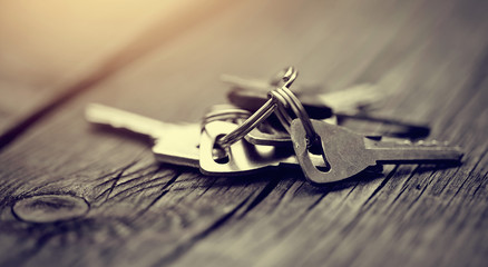 Bunch of keys on a wooden table.