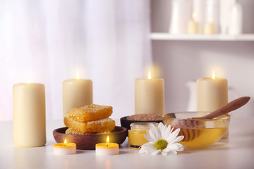 Fototapeta na wymiar Spa set with honey treatments and candles on white table