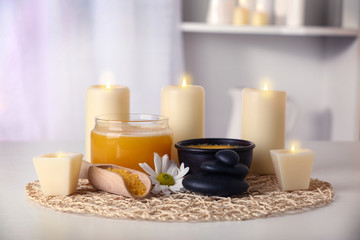 Fototapeta na wymiar Spa set with honey treatments and candles on wicker mat