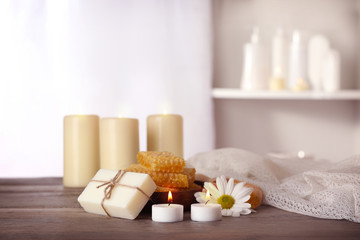 Spa set with honey treatments and candles on wooden table