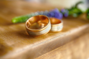 Obraz na płótnie Canvas Golden wedding rings on wooden background