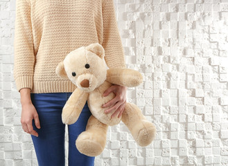 Child custody concept. Closeup of girl with teddy bear on white textured background