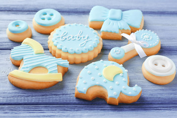 Baby cookies decorated with glaze on wooden background