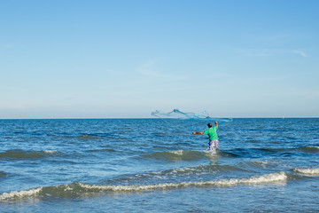Fishermen are casting nets at the beach.