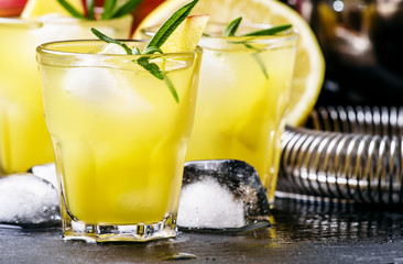 Mango lemonade, with rosemary, lemon juice and ice, black backgr