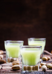 Homemade liqueur made from pistachios, old wooden background, se