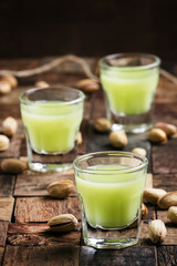 Homemade liqueur made from pistachios, old wooden background, se