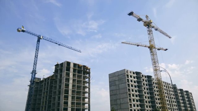 Modern building site with working cranes at bright sunny day