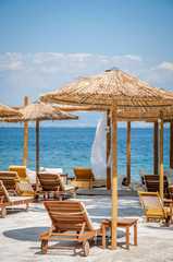 Beach with wooden umbrellas and sunbeds
