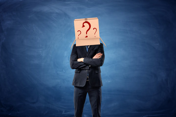 Businessman is wearing cardboard box with drawn question marks on his head