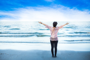 Woman arms raised on the beach