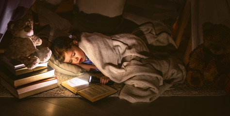 child girl sleeping in tent with  book and flashlight © JenkoAtaman