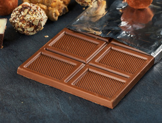 Bar milk chocolate close up with chocolate candies