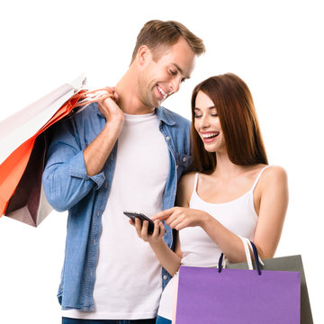 Couple with shopping bags and cellphone, on white