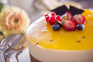 Yellow cheesecake with strawberries, blueberries, redcurratns an