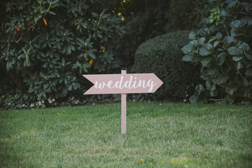 Wooden Sign Pointing Towards Wedding Ceremony