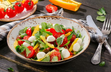 Healthy salad with mozzarella on wooden table.