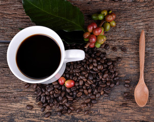 Cup of coffee beans on the wooden floor.