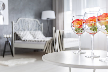 Roses in glasses in bedroom